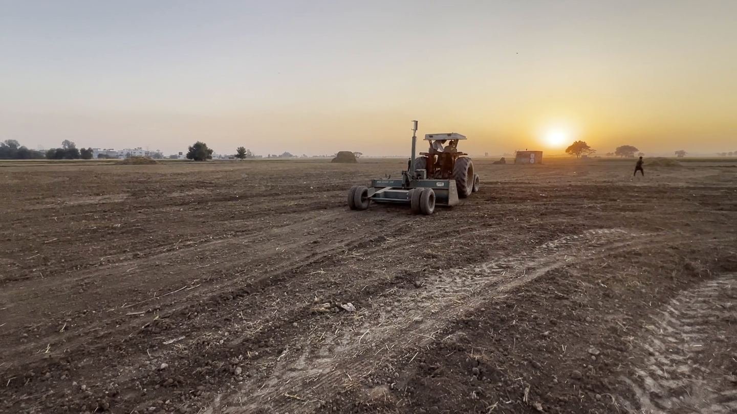 Tractor working a field at sunset