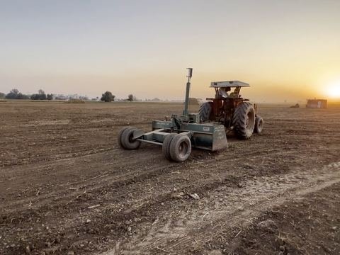 Tractor with a laser land leveller in a field