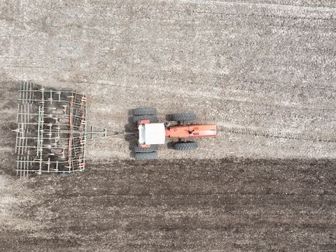 Top view of a tractor working the soil in a field