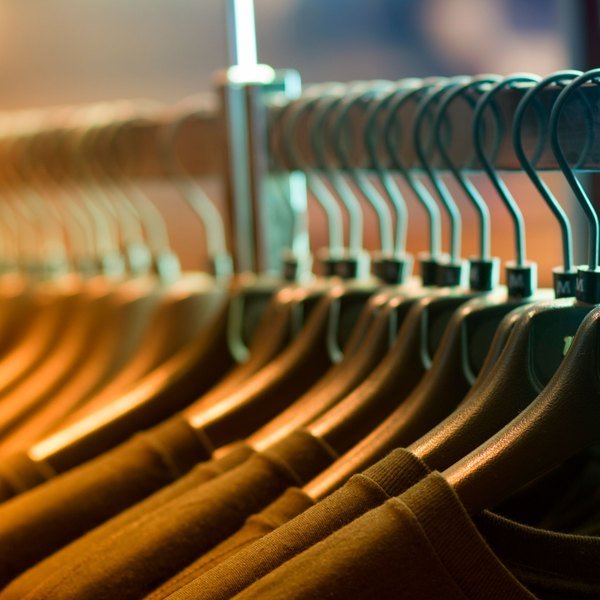 Shirts hanging on wooden hangers on a rail