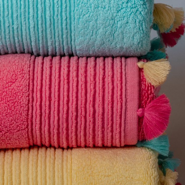 Stack of folded towels in teal, pink and yellow