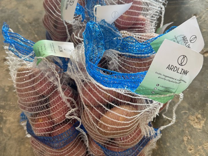 Red potatoes in blue mesh bags with ARDLINK tags